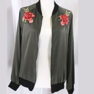 Green bomber jacket with coral colored roses